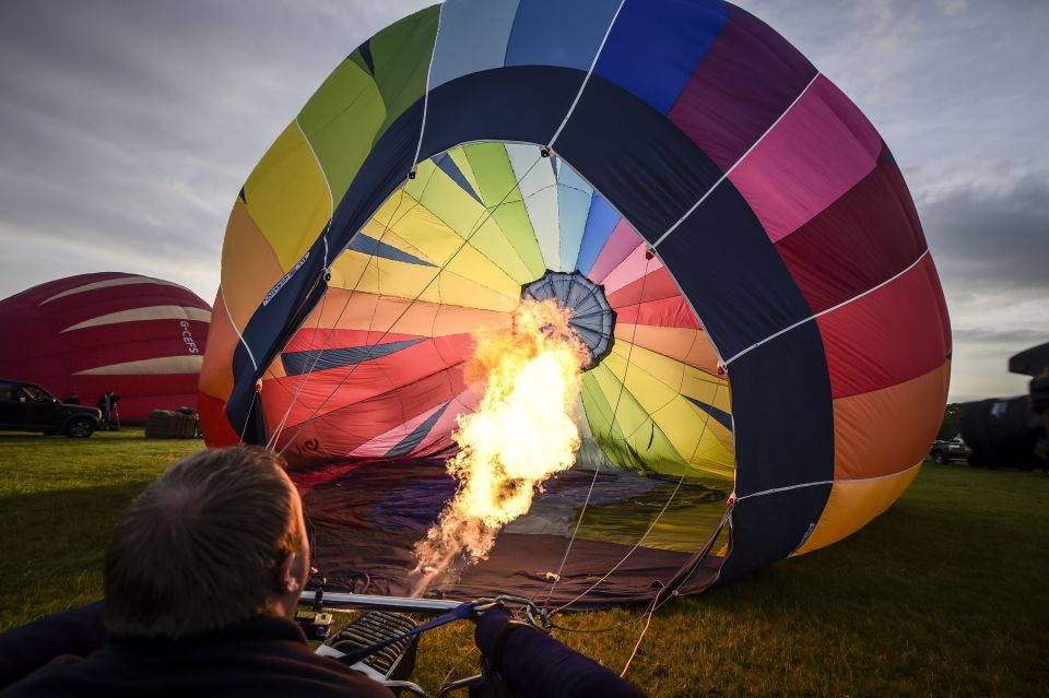 A balloon pilot checks his burner and inflates the balloon in preparation for flight from Clifton Downs, Bristol