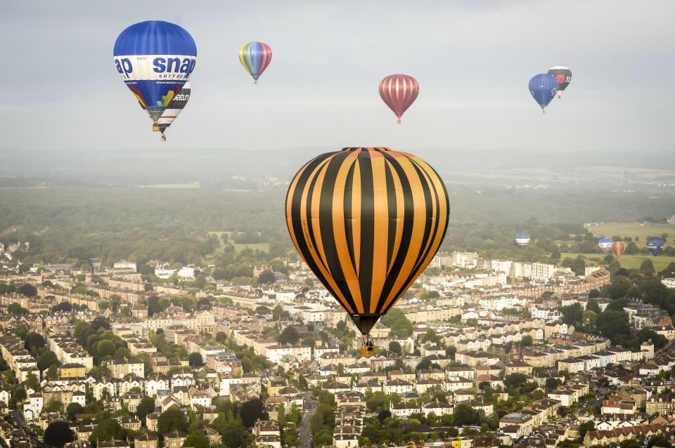 Hot air balloons pass over the city of Bristol during a mass balloon launch from Clifton Downs
