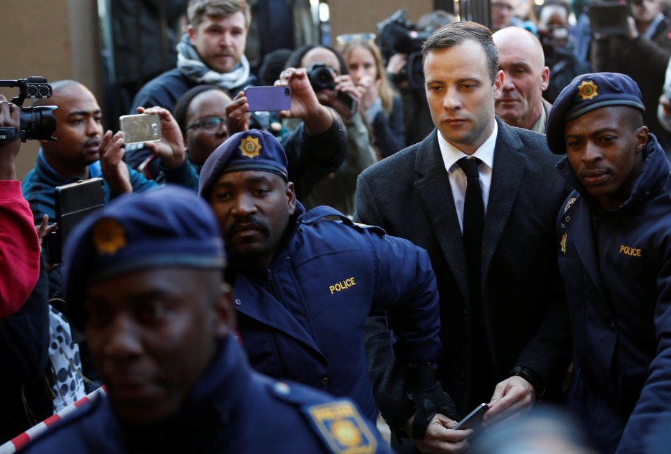 Pistorius is escorted by police officers as he arrives for his sentencing for the 2013 murder of his girlfriend Reeva Steenkamp, at Pretoria High Court