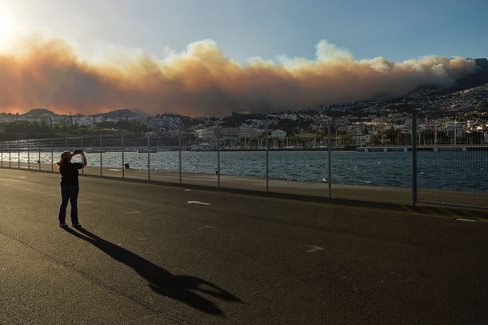 The thick, black smoke being fanned by the wind has also caused disruption at the island's airport