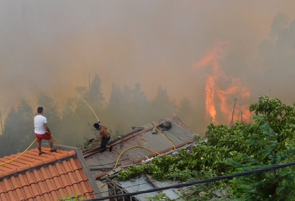 Desperate locals could be seen battling to keep the inferno at bay using anything they could get their hands on