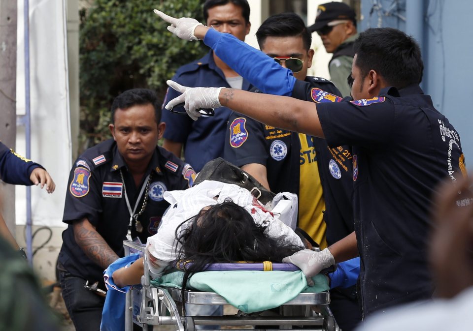 Thai rescue workers rush an injured bomb victim to a hospital following a bomb attack at the city clock tower in the center of Hua Hin