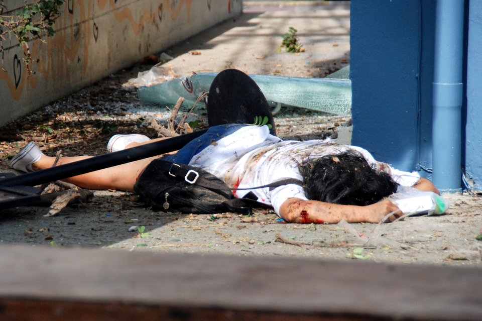 An injured woman lies in the street after yesterday's bombings in the town of Hua Hin, south of Thai capital Bangkok