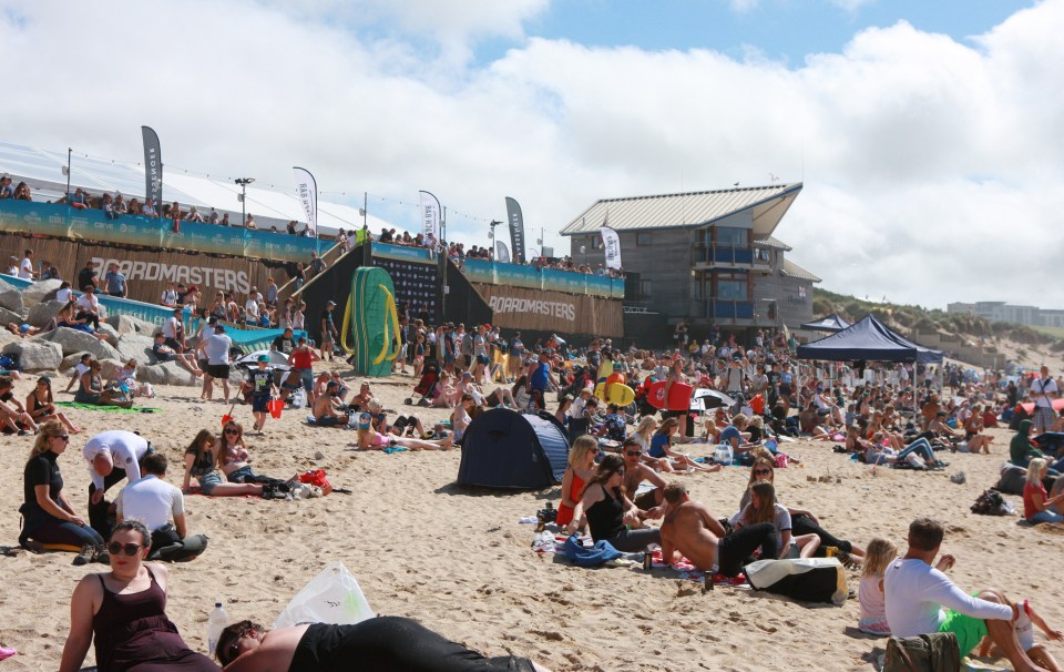 People Enjoying The Sun At Fistral Beach In England