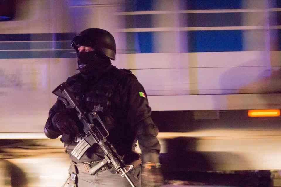 A masked Mexican cop stands guard during a security operation