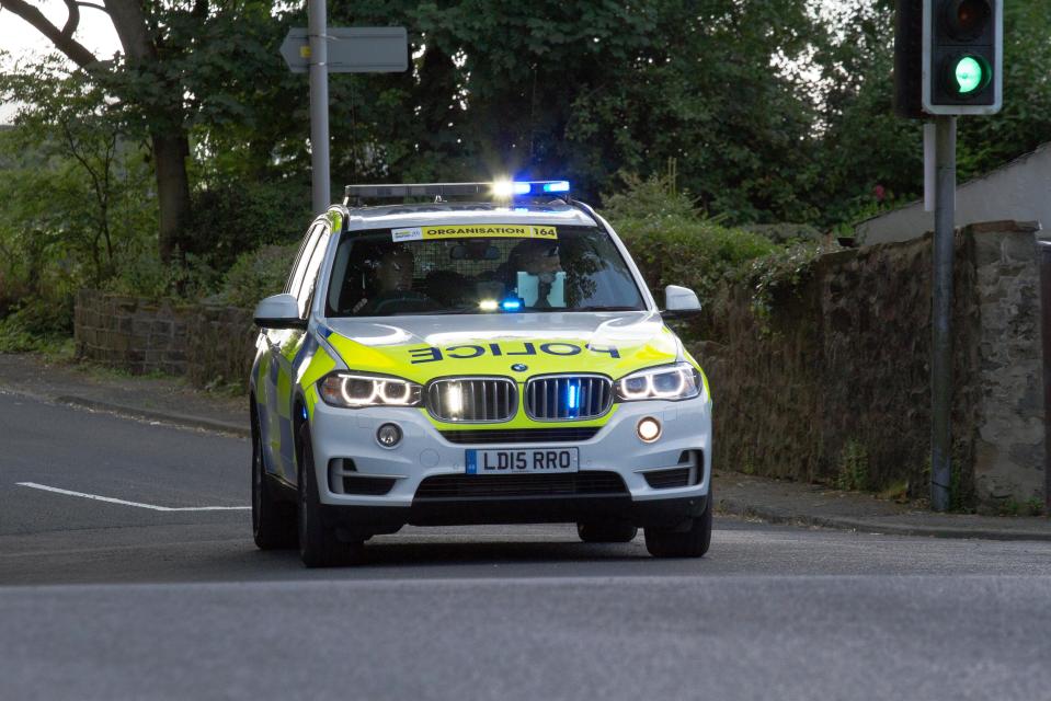 Police vehicles responding with blue lights, Clitheroe, Lancashire, UK.