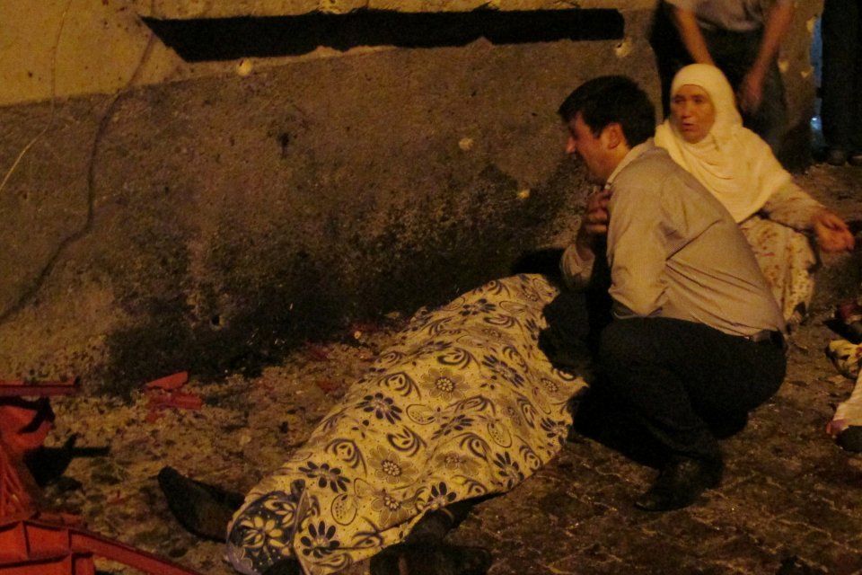 A man and a woman mourn next to a body of one the victims 