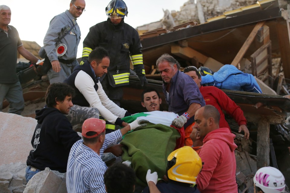 Rescuers ferry away one of the survivors from the rubble in the central Italian town