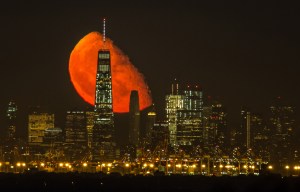 Stunning picture shows the moon glowing BLOOD RED as it looms large over the new World Trade Center