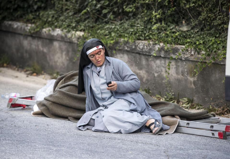 An injured nun lies in the street in the town of Amatrice. Pope Francis led prayers for the victims of the quake on Wednesday morning