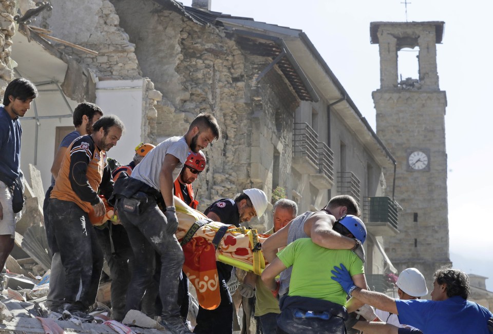 Rescuers carry away those injured by the quake after desperately clawing through the rubble with their bare hands