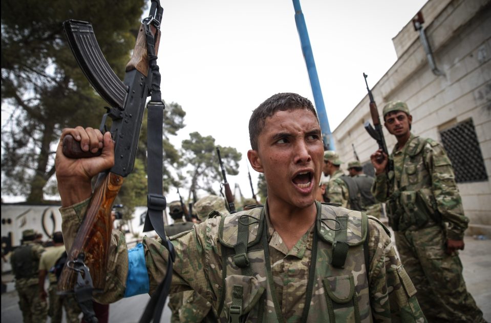 A member of the Free Syrian Army (FSA) cheers after routing ISIS from Jarabulus