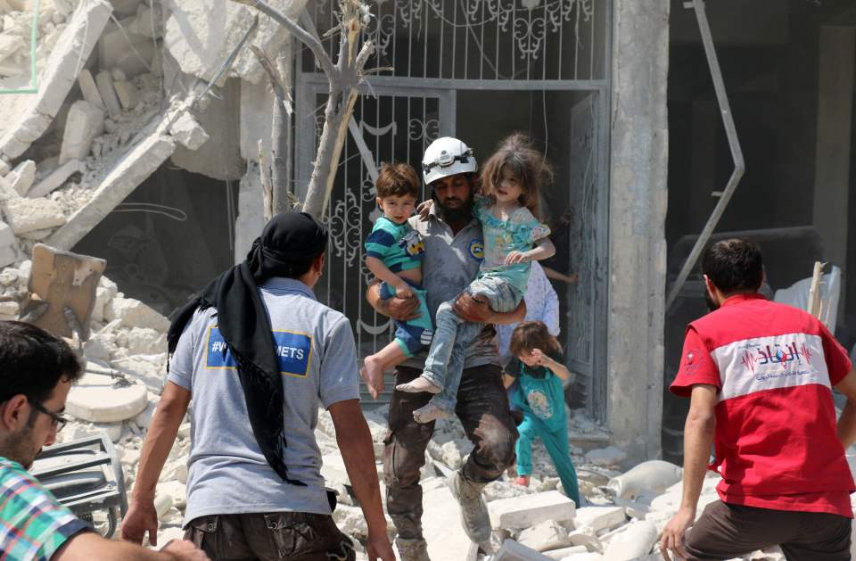 Rescuer carries tots away from collapsed building after devastating attack