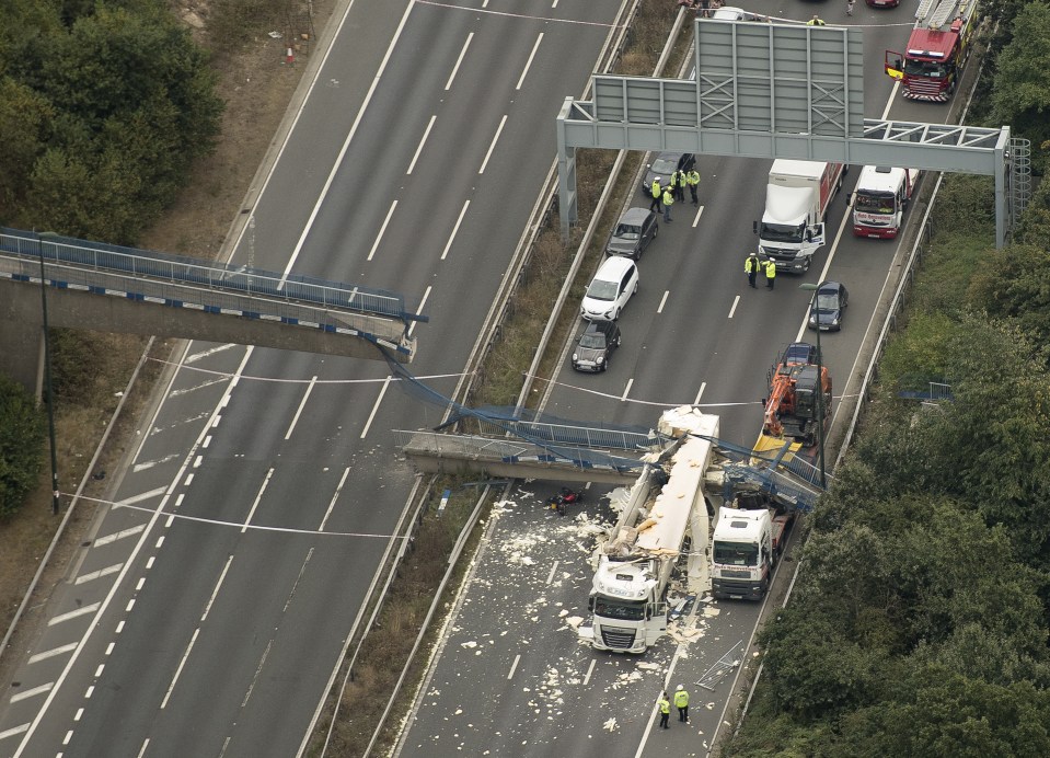 Half the footbridge collapsed on two lorries after a truck carrying a digger crashed into it