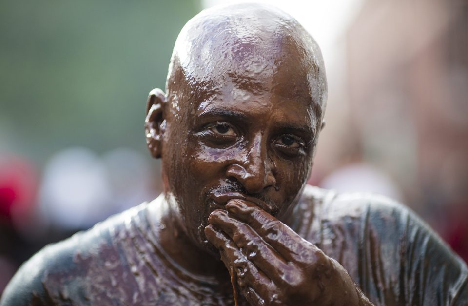 A man gazes into the camera after smothering himself in chocolate