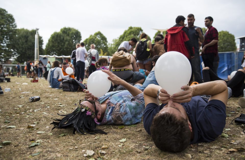 Revellers lie down and inhale from suspicious balloons