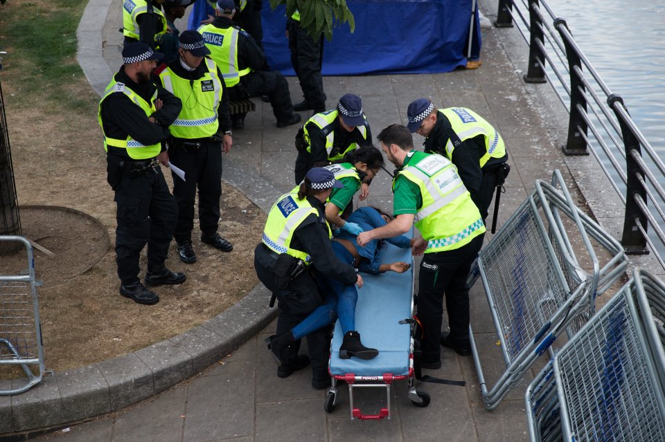 Another woman is put onto a stretcher by the authorities