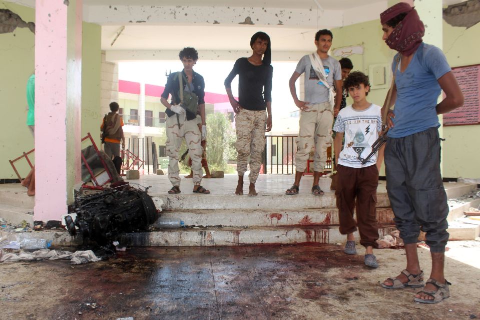 Yemenis look at a blood stained floor at