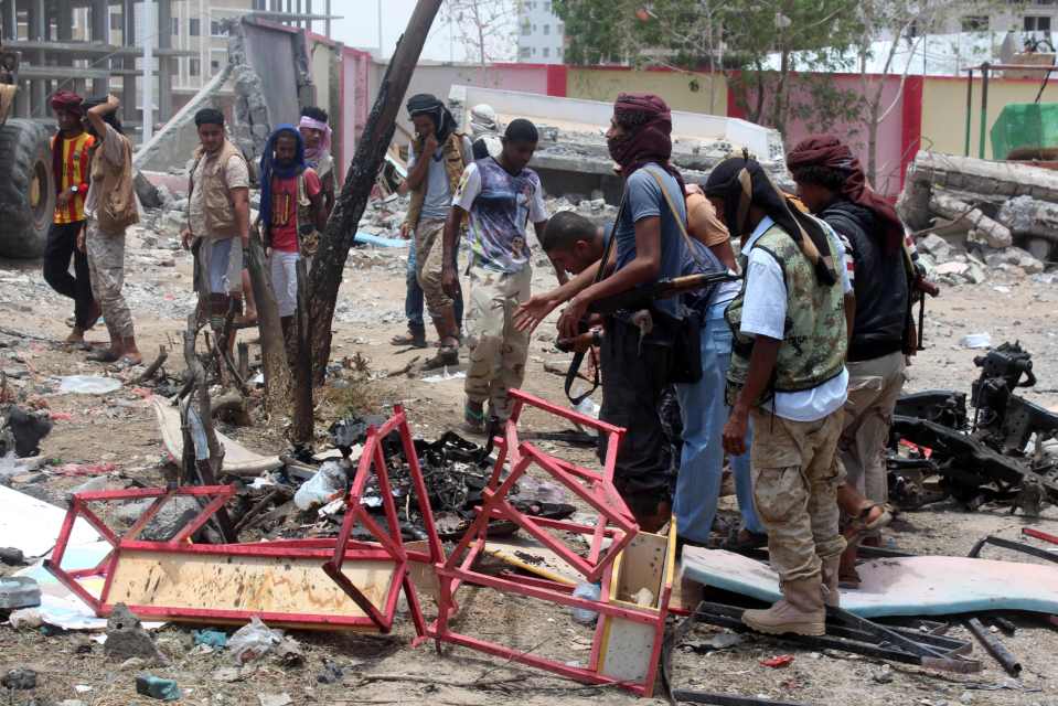 Yemenis, including soldiers, inspect the