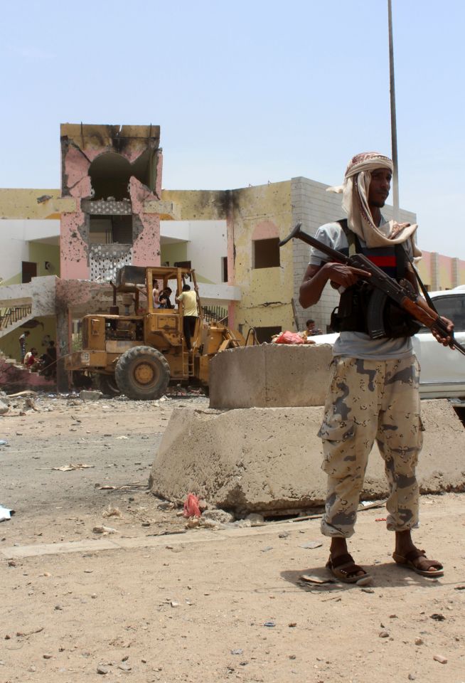 A member of Yemeni security forces stand