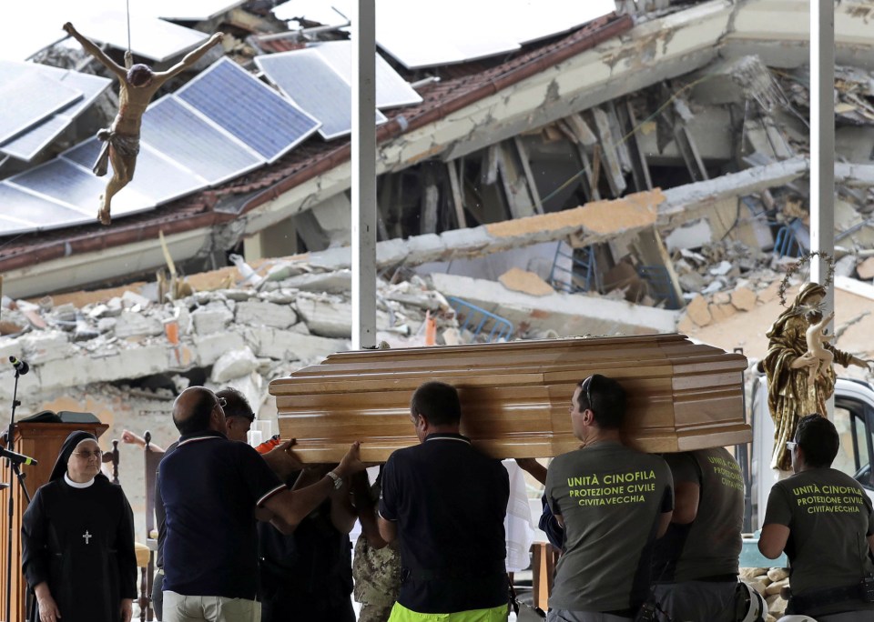 The coffins of victims are carried into the service in the Italian town of Amatrice on Wednesday