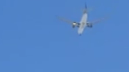 Flames are seen blasting from the left side engine of the jet