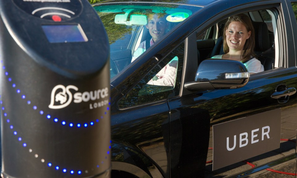 An Uber electric taxi shown parked at a charging point