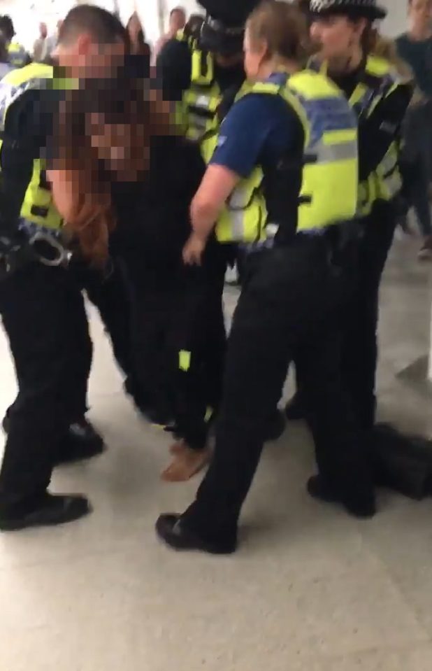 The woman was held down by six police officers, often appealing to the camera as she resisted arrest