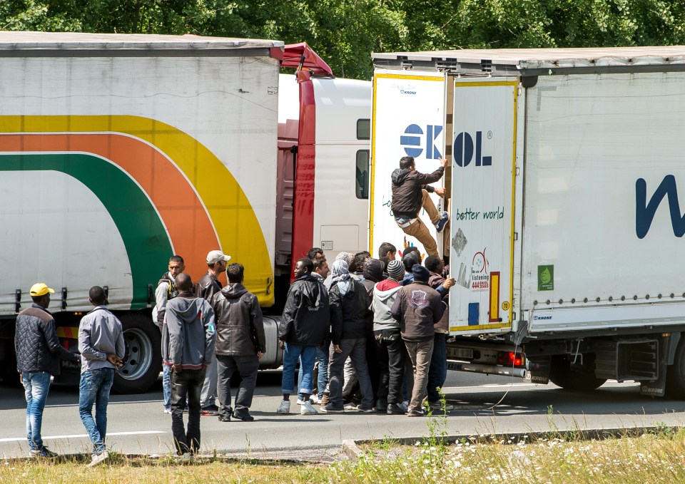 Migrants climb in the back of a lorry