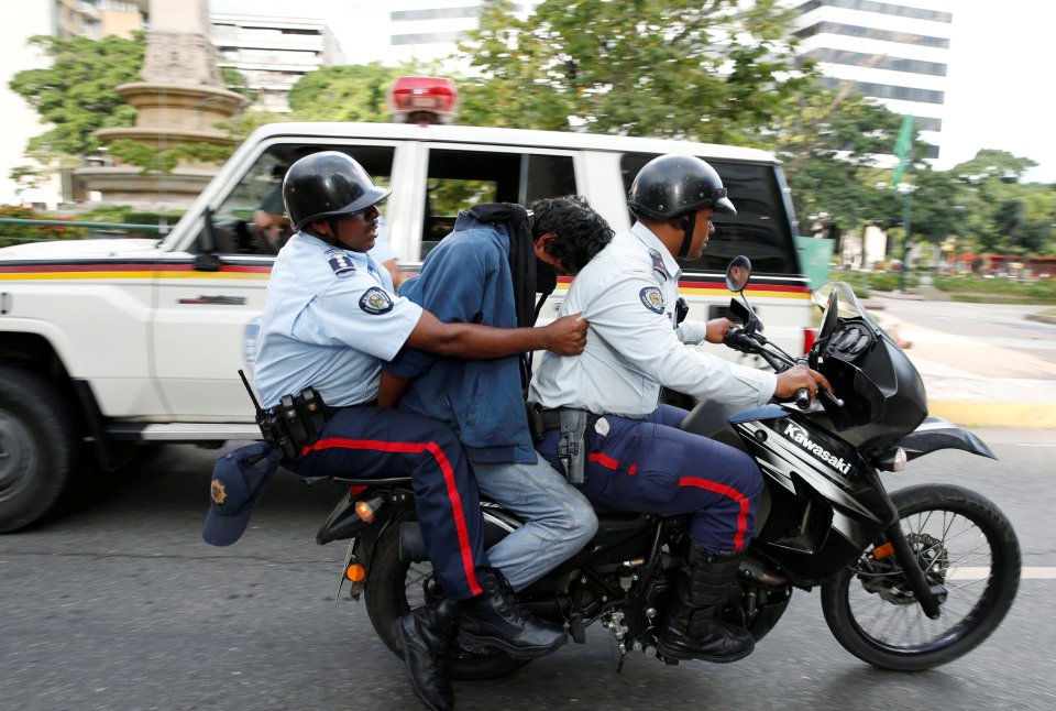 A protester is detained during a rally to demand for a referendum to remove Venezuela's President Maduro in Caracas