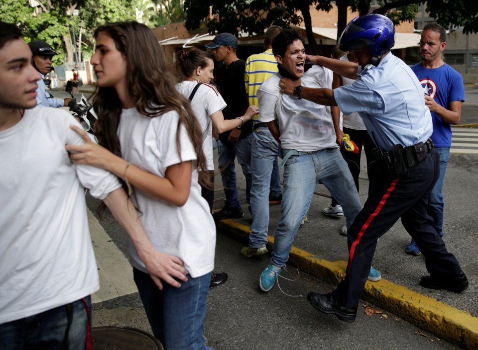 A protester is detained during a rally to demand for a referendum to remove Venezuela's President Maduro in Caracas