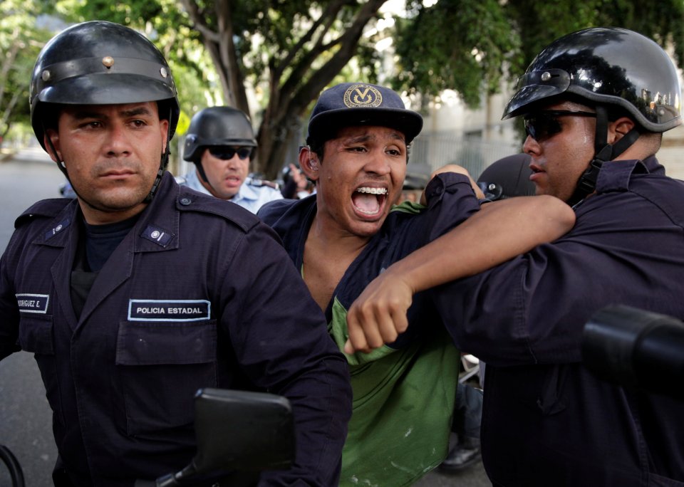 A protester is detained during a rally to demand for a referendum to remove Venezuela's President Maduro in Caracas