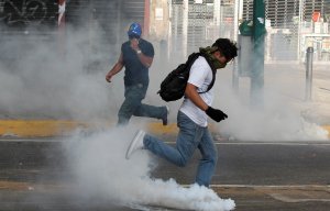Riot police use teargas after mass protests in Venezuela against socialist regime