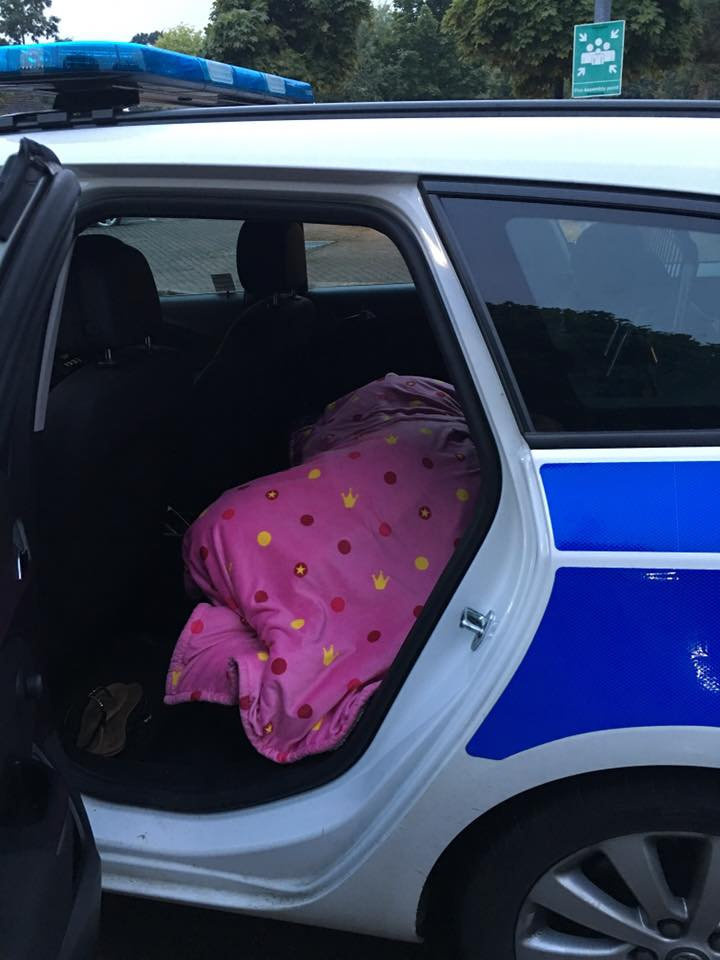 The shocking photo shows Katie asleep under a blanket in the back of a police car
