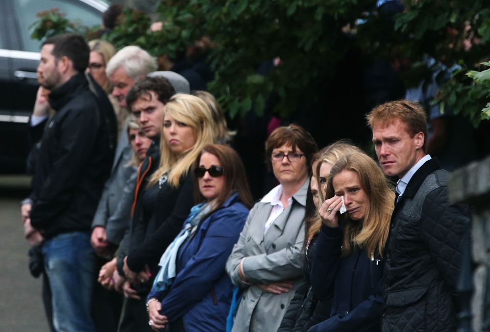 Lining the streets . . . tearful crowds watched hearses go by