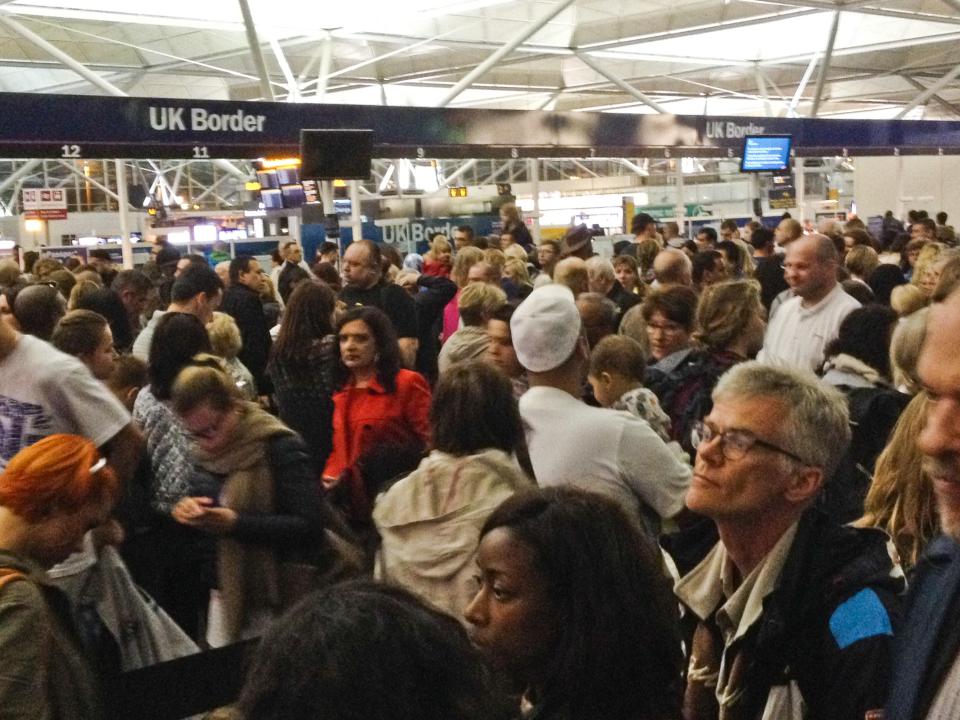 Passengers wait at passport control