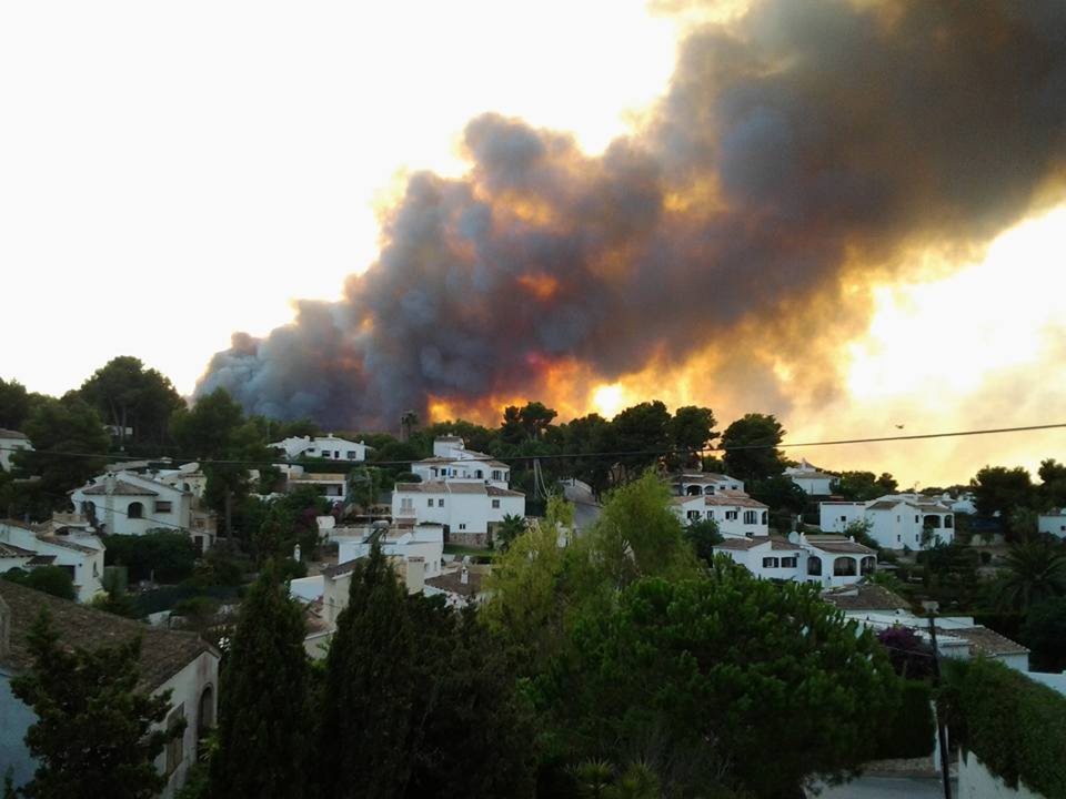 A huge forest fire is raging across the hills surrounding the Costa Blanca resort of Javea, threatening to scorch homes and forcing the evacuation of hundreds of holidaymakers.