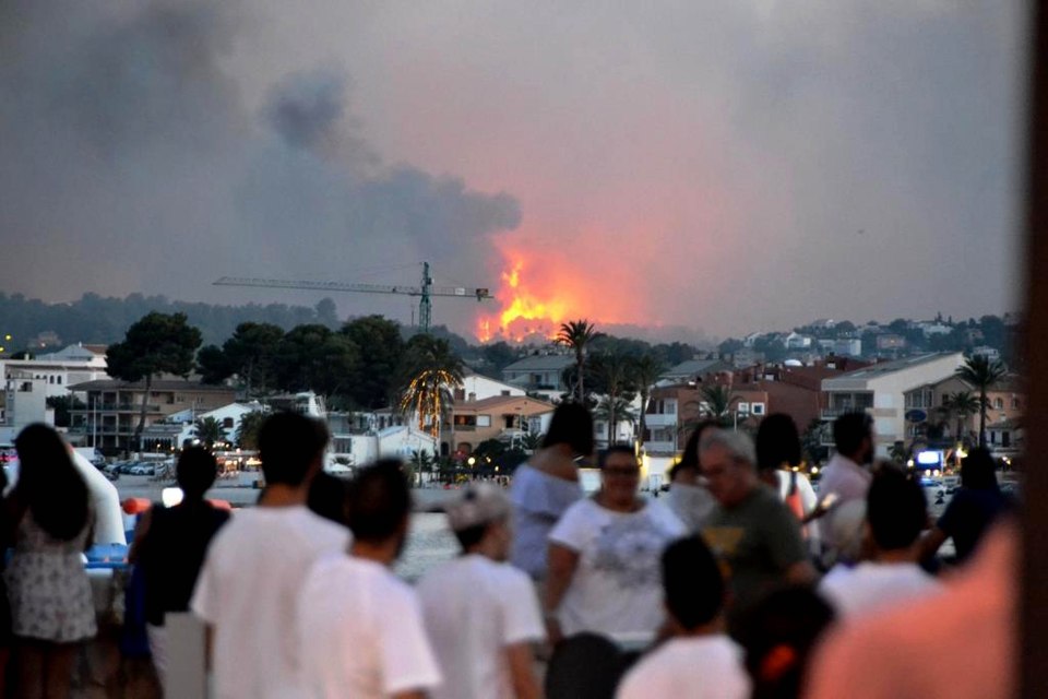 A huge forest fire is raging across the hills surrounding the Costa Blanca resort of Javea, threatening to scorch homes and forcing the evacuation of hundreds of holidaymakers.