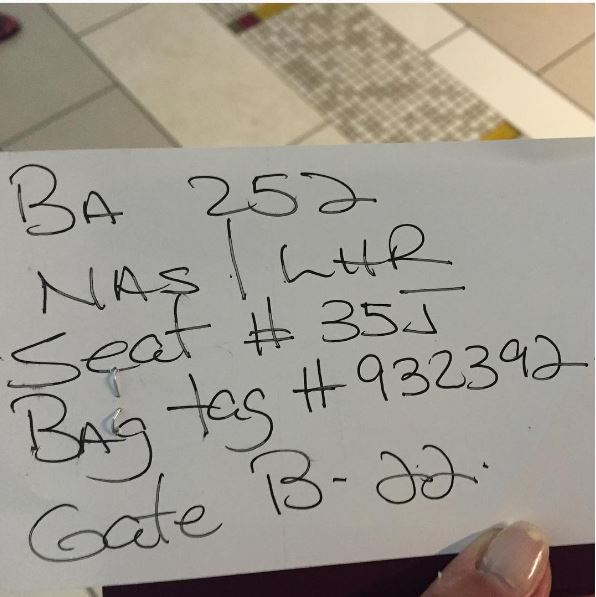 A BA customer in the Bahamas holds their handwritten boarding pass