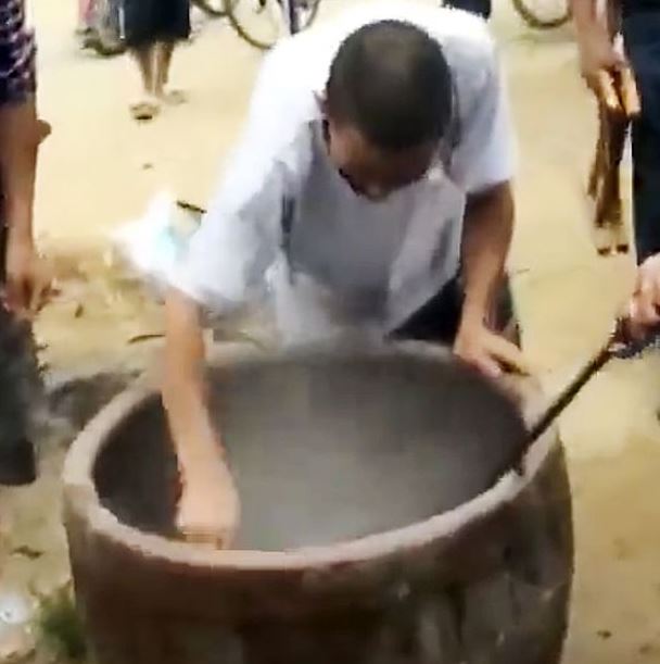 The man goes back into the pot to retrieve the animal