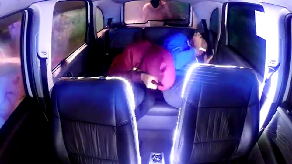 A young pair of cab passengers huddle together as the alien actors bang on the vehicle