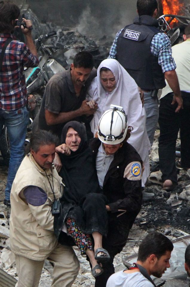  Syrian rescue workers and civilians evacuate victims from the scene of a reported air strike on the rebel-held northwestern city