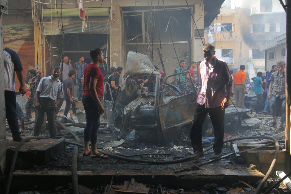 Residents inspect a damaged site after airstrikes on the market in the city