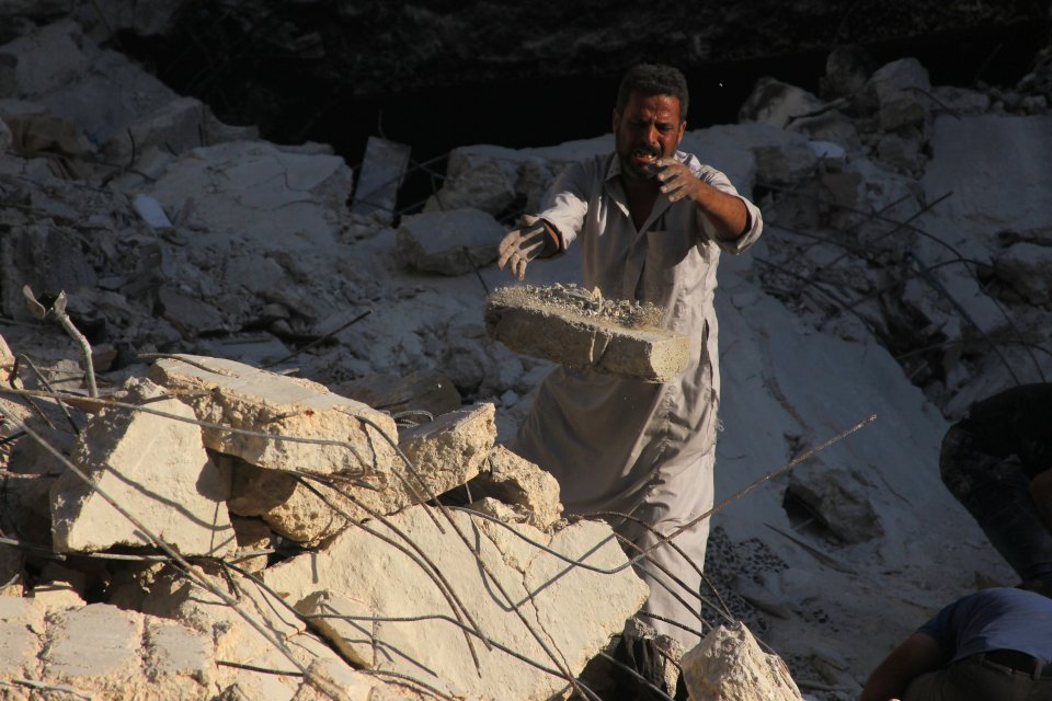 A man removes rubble in a damaged site after the airstrike
