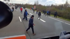 The driver swerves towards the migrants at the side of the road
