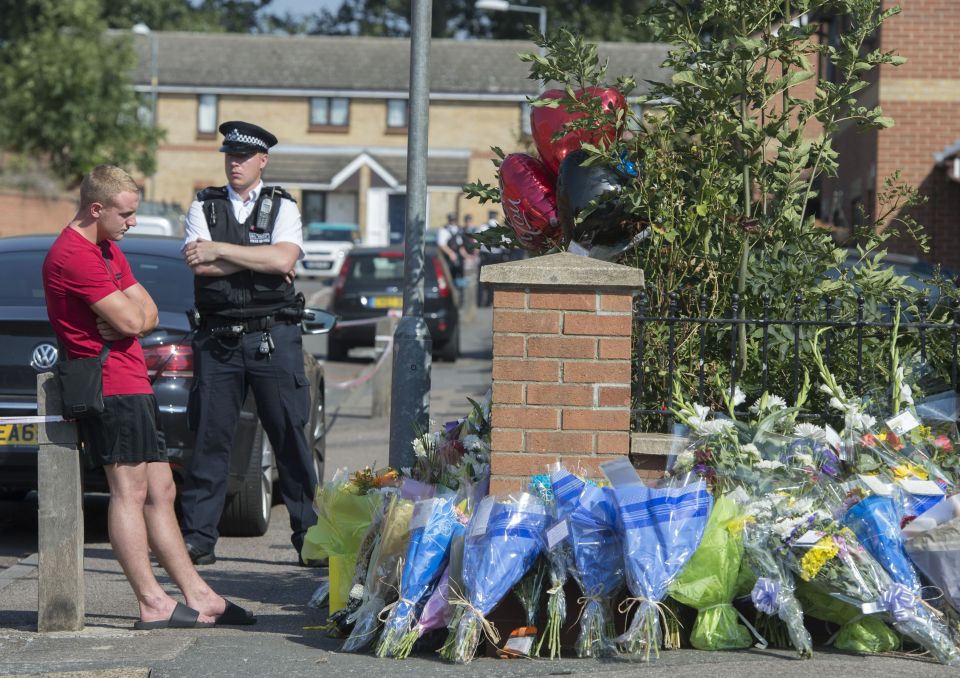 Perry Hayden looks at foral tributes at the scene in Chadwell Heath, east London, where his brother, Ricky Hayden, was fatally stabbed