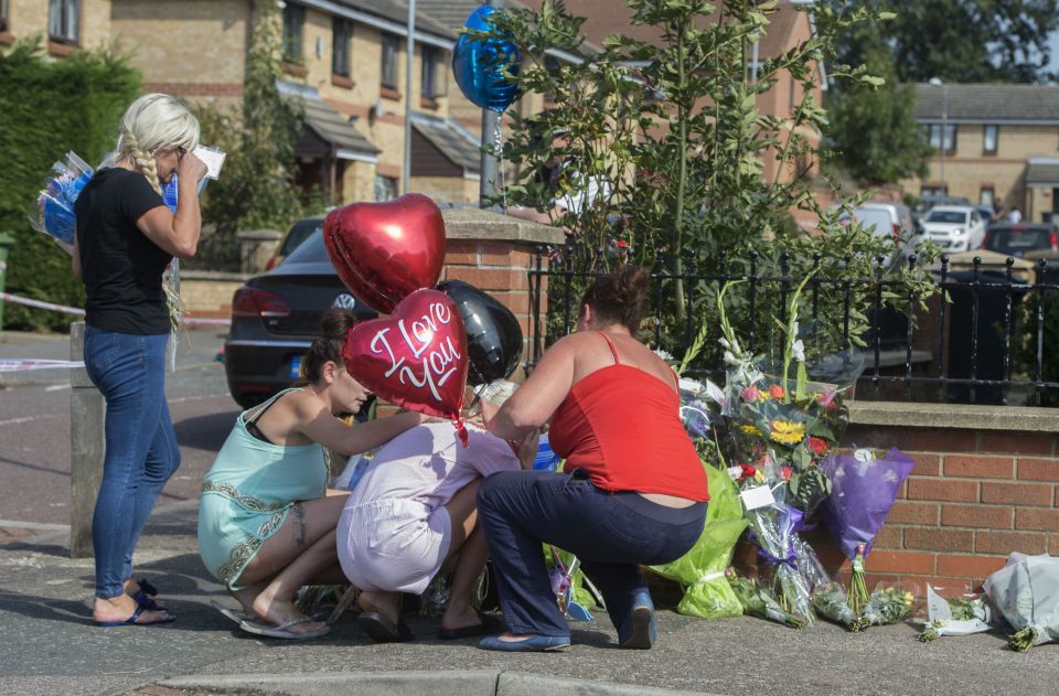 April Hayden (second right) leaves flowers at the scene in Chadwell Heath