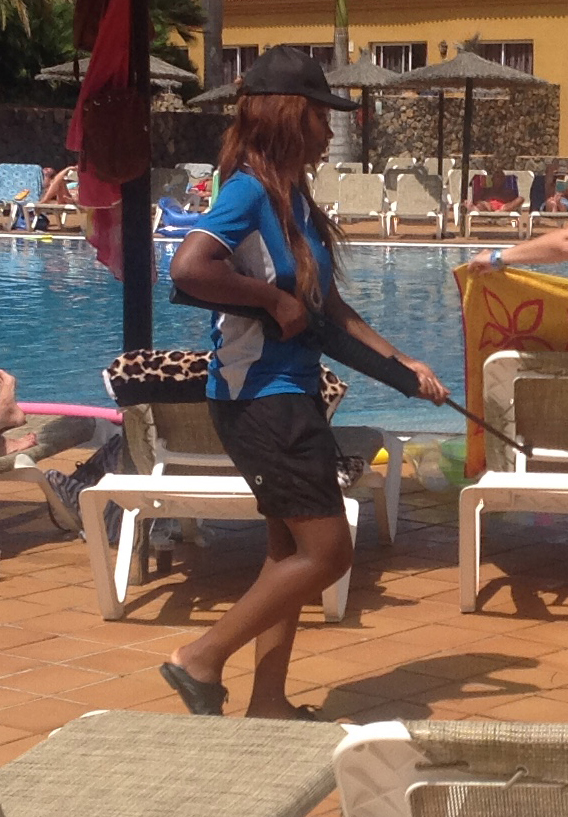 The Fuerteventura hotel worker wanders past tourists brandishing the gun