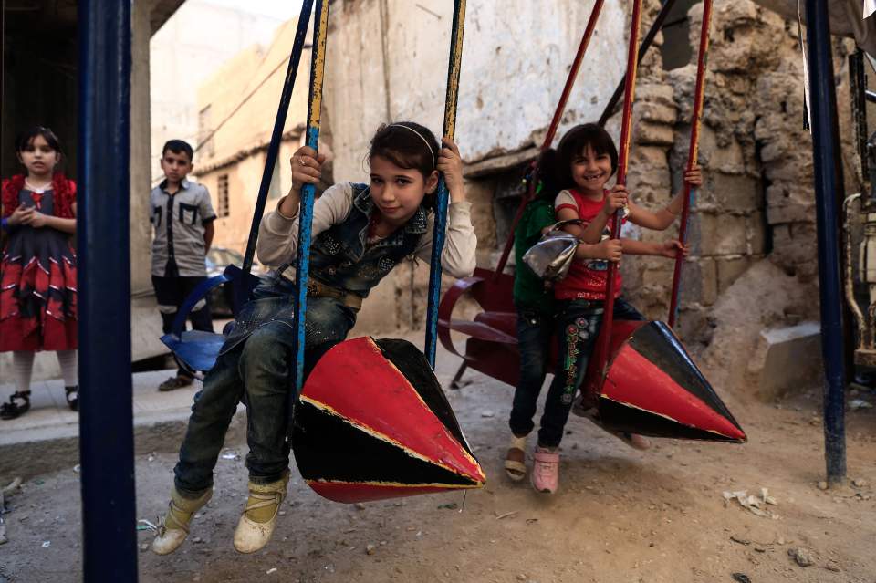 Syrian children play on swings, made fro