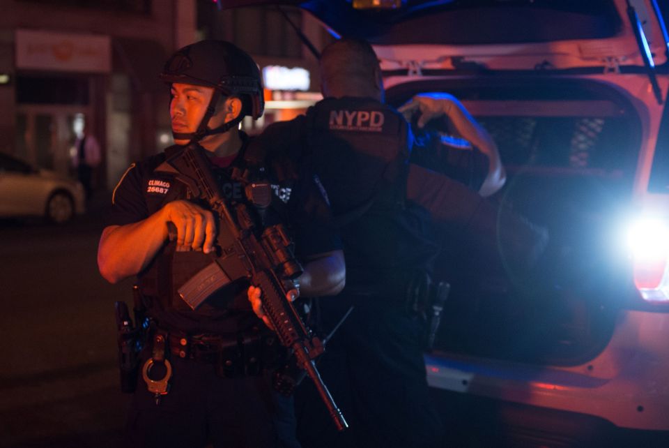 Police officers look on near the site of